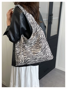 Detail view of large zebra pattern tote bag worn over the shoulder for casual style
