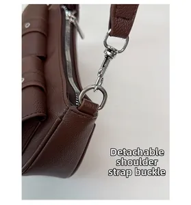 Close-up of polished silver buckle and stitching on a brown leather shoulder bag