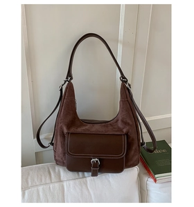 Detailed close-up of brown frosted leather hobo bag with white contrast stitching and buckle