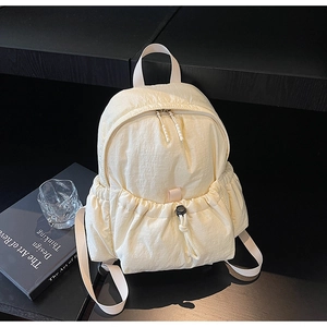 Detailed macro view of off-white backpack featuring pleated fabric and drawstring pockets