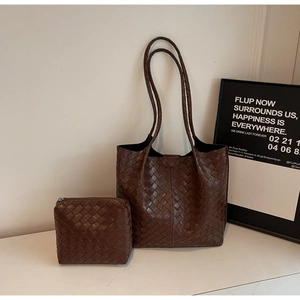 Close-up of brown leather woven tote set with matching interior zipper pouch