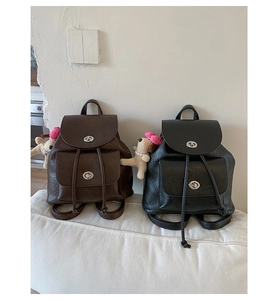 Detailansicht von Vintage-Mini-Rucksäcken in Braun und Schwarz mit Welpenanhängern