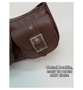 Detail of dark brown lychee leather bag with silver metal buckle and zipper closure