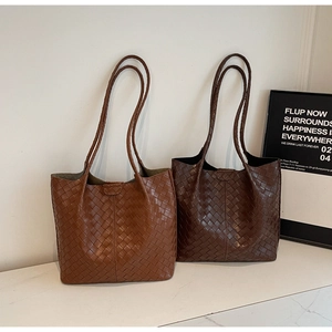 Detailed view of large woven tote bags in light and dark brown leather texture