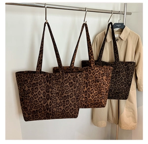 Vista dettagliata di tre borse shopper in tela con stampa leopardata in diverse tonalità