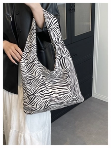 Zebra print large tote bag shown on model in a stylish indoor lifestyle setting