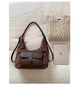 Detailed close-up of retro brown frosted suede shoulder bag with metal buckle and contrast stitching