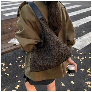 Straßenansicht eines Models mit einer Leopard-Print-Tasche und Lederriemen