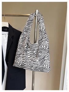 Detail view of large zebra print canvas tote bag showing soft hobo texture and shoulder strap