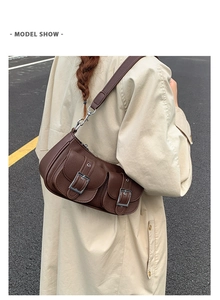 Rear view of a model wearing the brown leather crescent bag with double front buckle pockets