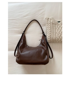 Detailed top view of dark brown faux leather hobo bag with suede panels on soft fabric