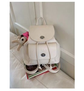 Detailansicht des cremefarbenen Vintage-Rucksacks aus PU-Leder mit Verschluss und Plüschhund