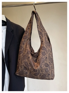 Detailed macro view of brown paisley pattern on a large capacity tote shoulder bag