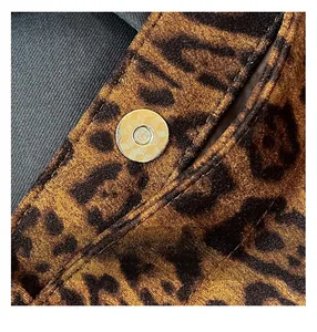 Dettaglio macro della borsa tote leopardata con fibbia magnetica dorata testurizzata