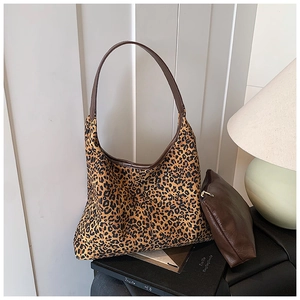 Detailansicht der Hobo-Bag mit Leopardenmuster und brauner Clutch auf Kunstbüchern