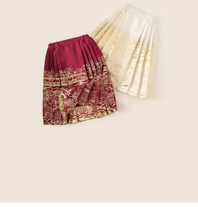 Detail of girls traditional Chinese pleated skirt with gold patterns in red and beige