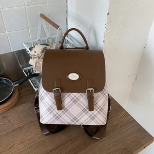 Detail of pink plaid backpack featuring brown leather flap and cute rabbit logo