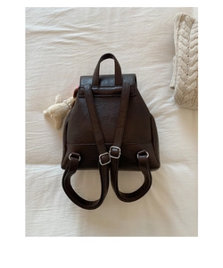 Detailansicht des Vintage-Rucksacks in Dunkelbraun mit verstellbaren Trägern und Plüschbär-Anhänger