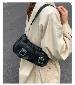 Detail of black pebbled leather underarm bag with silver buckles and dual pockets