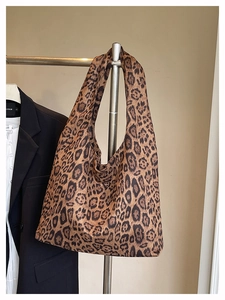 Detail view of fashion leopard print tote bag hanging on metal rack for casual look