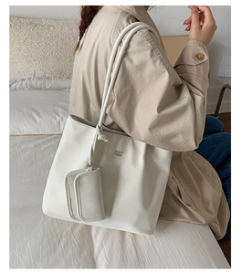Detailed view of the large white PU leather tote bag with brand logo and matching pouch