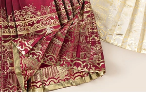 Macro view of Chinese New Year pleat skirt featuring luxury gold foil patterns and fabric texture