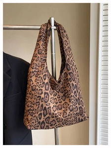 Detail shot of leopard print tote bag hanging on a hanger with a casual blazer