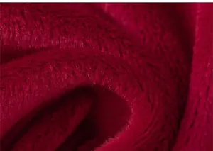 Macro shot of deep red faux fur fabric showing soft plush texture and warmth for winter skirts