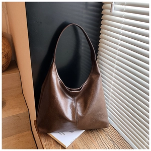 Detailansicht der dunkelbraunen Leder-Hobo-Tasche mit Öl-Wachs-Textur und vertikaler Naht