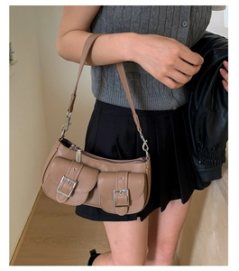 Detail of retro tan pebble leather underarm bag with silver buckles and utility pockets