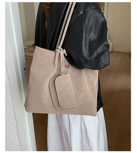 Detailed view of beige faux leather tote bag with long straps worn on the shoulder
