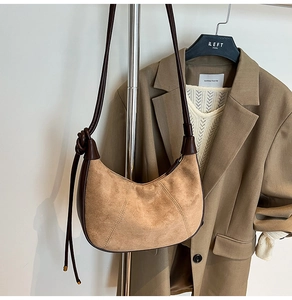 Detail view of brown faux suede hobo bag with distinctive knot strap and contrast stitching