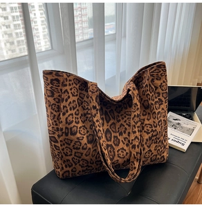 Borsa tote leopardata capiente con un computer portatile e riviste all'interno