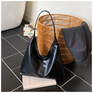 Nahaufnahme einer großen schwarzen Hobo-Tasche mit Metallschnalle in stilvollem Ambiente