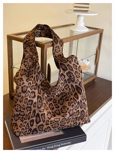 Detailed macro view of large leopard print canvas tote bag on a dark decorative book