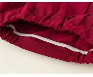 Detail of red jacquard fabric sleeve with elastic cuff and white piping craftsmanship