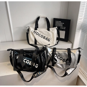 Tre borse sportive alla moda in nero, bianco e argento su scale con luce naturale