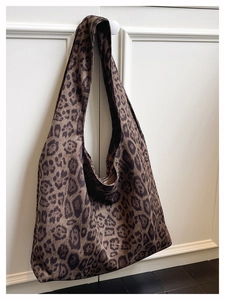 Detail of leopard print canvas tote bag texture hanging on white cabinet handle