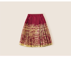 Detailed view of red Mamian skirt featuring traditional gold embroidery and pleated hem