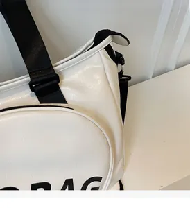 Dettaglio della texture in pelle PU bianca e cinturino in nylon nero sulla borsa sportiva