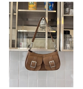 Detail of vintage brown textured leather underarm bag with silver buckle flap pockets