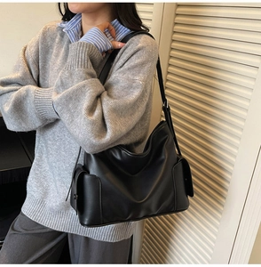 Detail of black faux leather tote bag with functional side pocket for daily commute