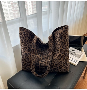 Dettaglio della borsa tote in tela leopardata su una seduta in pelle moderna