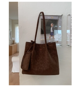Close-up of a large dark brown leather tote bag with vintage texture and PAN TOR logo