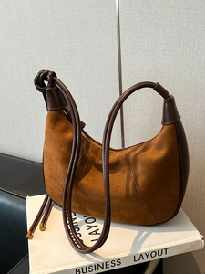 Vintage brown suede moon bag with leather cord handle and elegant golden metal accents