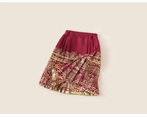 Detail of red Mamian skirt with golden foil traditional building and cloud patterns