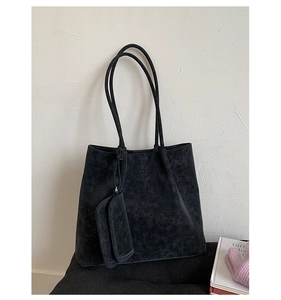 Detail of black suede tote bag with PAN TOR logo and small side attachment pouch