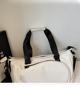 Dettaglio della borsa sportiva in ecopelle bianca con logo NOCOBAG e manici rinforzati