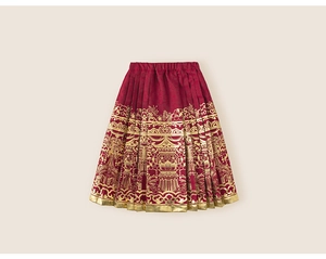 Detailed close-up of red and gold Chinese pleated skirt with traditional embroidery