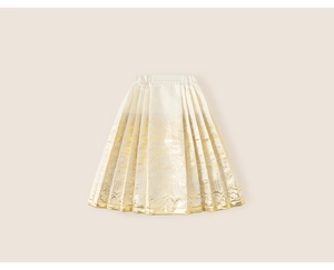Detailed close-up of a girls' pleated skirt with golden traditional floral patterns